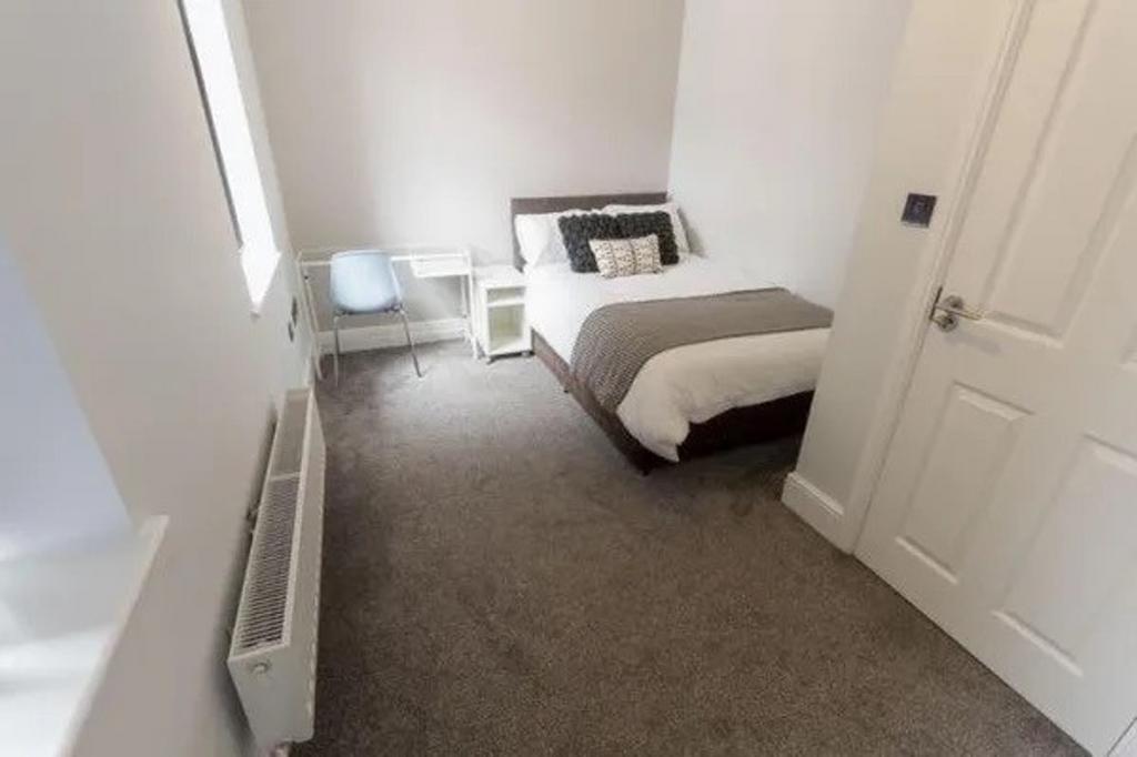 A bright and cozy double bedroom featuring mode...