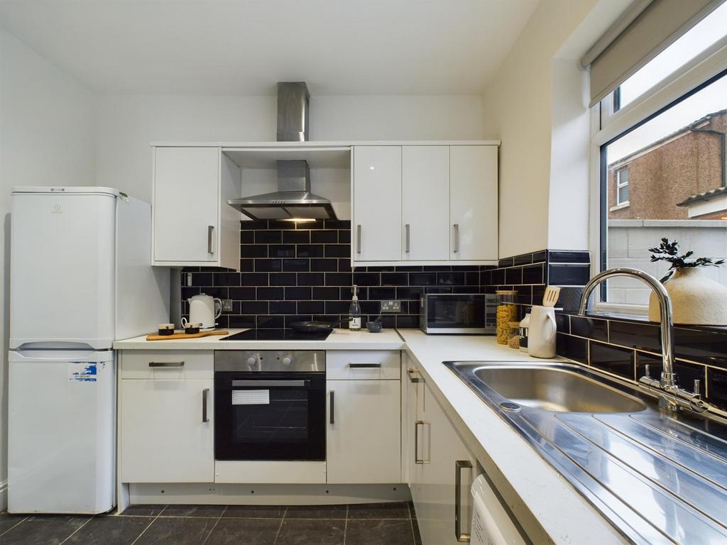 A modern and tidy kitchenette with ample natura...