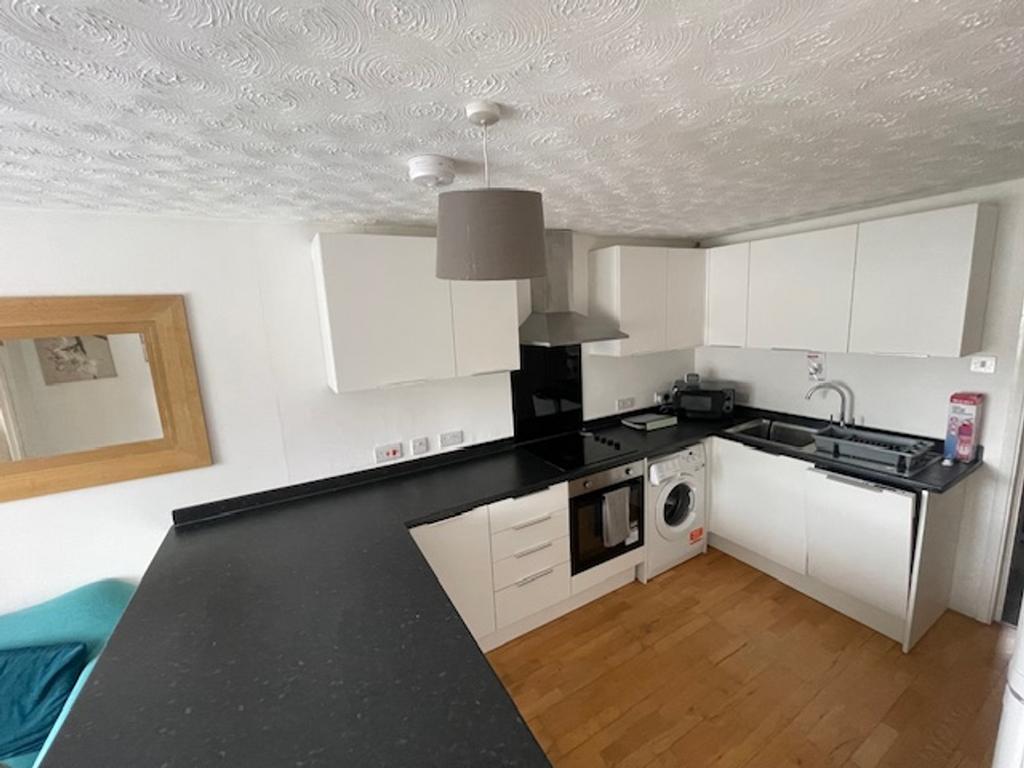 A modern and tidy kitchenette featuring ample s...