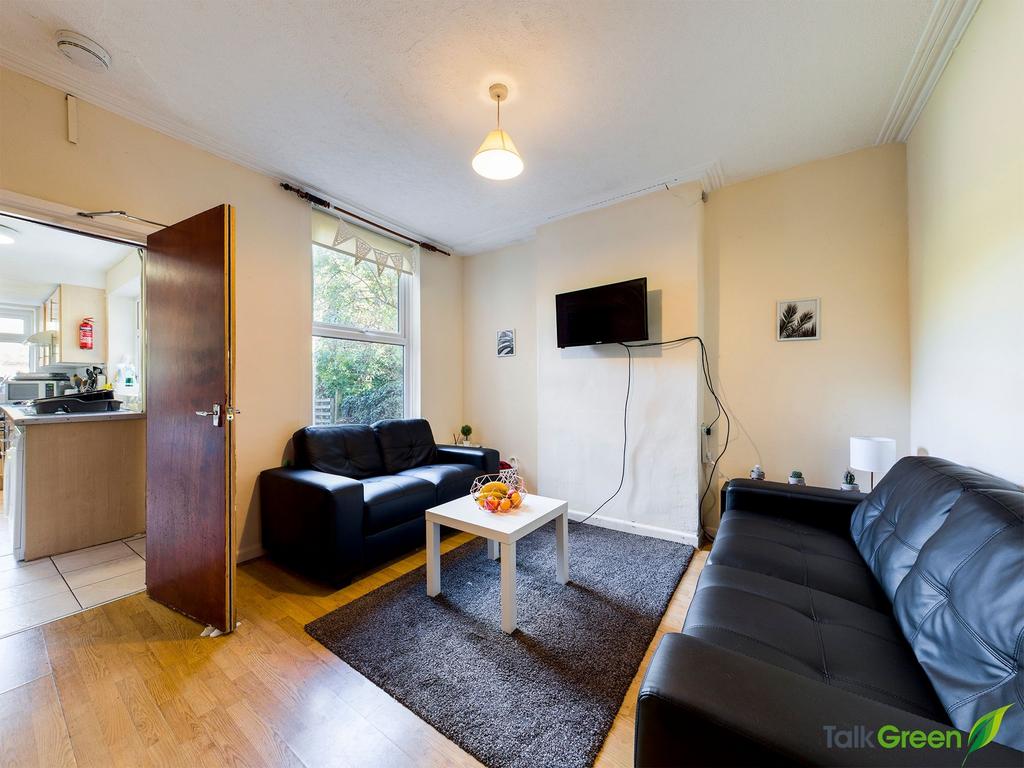 Bright furnished living room with two black lea...