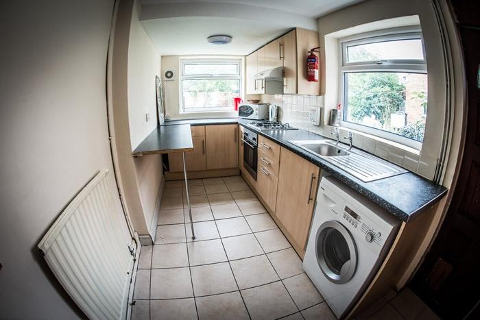 Bright galley kitchen with light wood cabinetry...