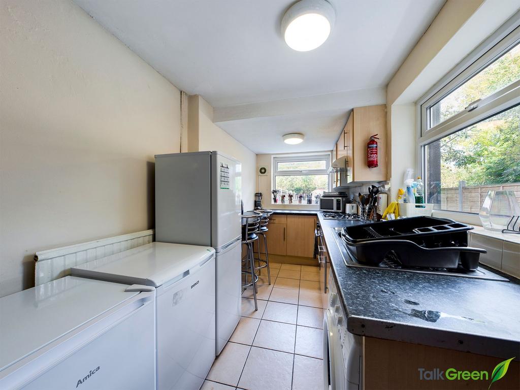 Bright galley kitchen with large windows overlo...
