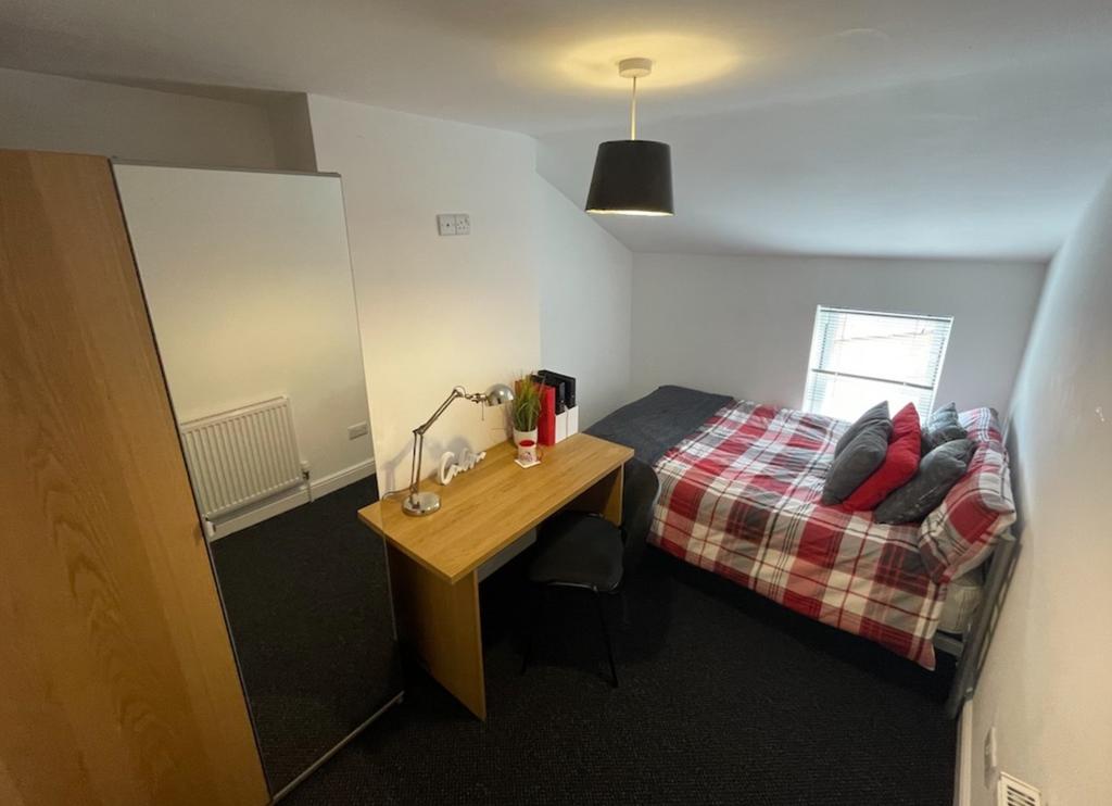 A bright and inviting double bedroom with a coz...
