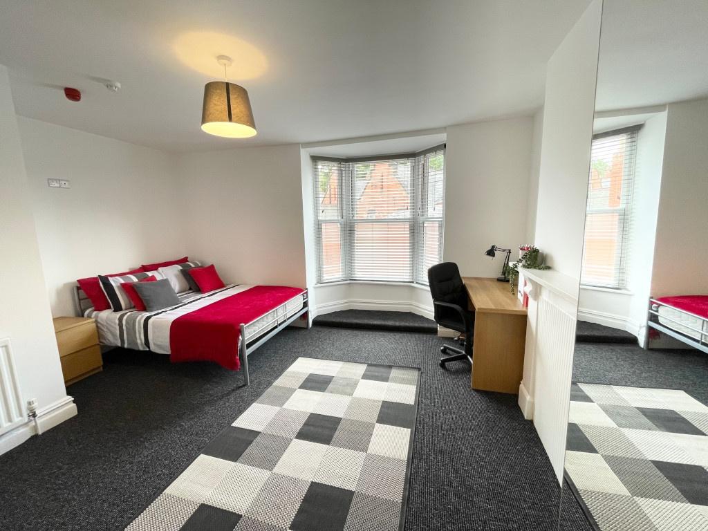 Spacious, bright bedroom with a bay window, con...