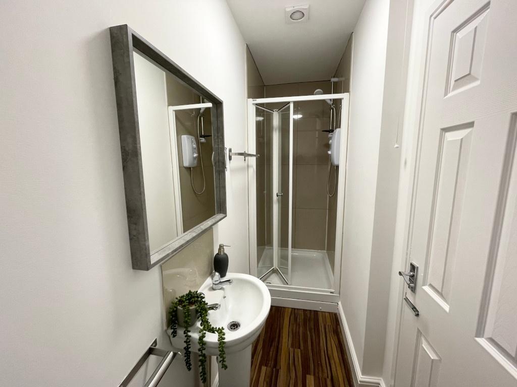 Bright, modern bathroom with a corner shower cu...