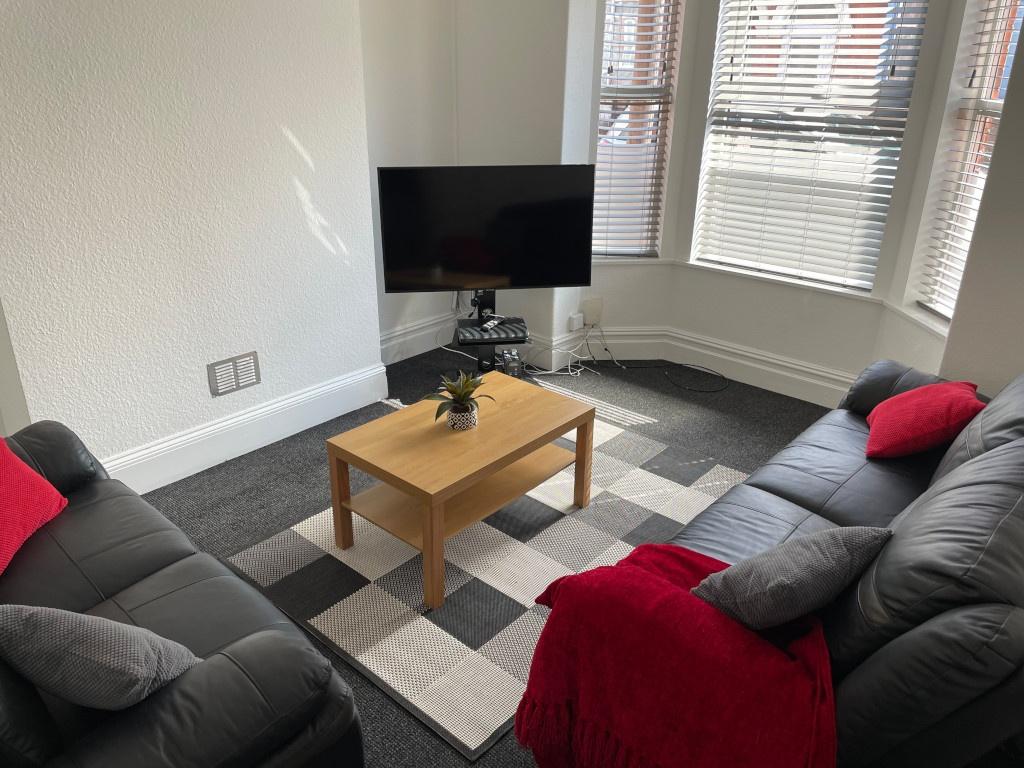 Bright, neatly presented living room with two b...