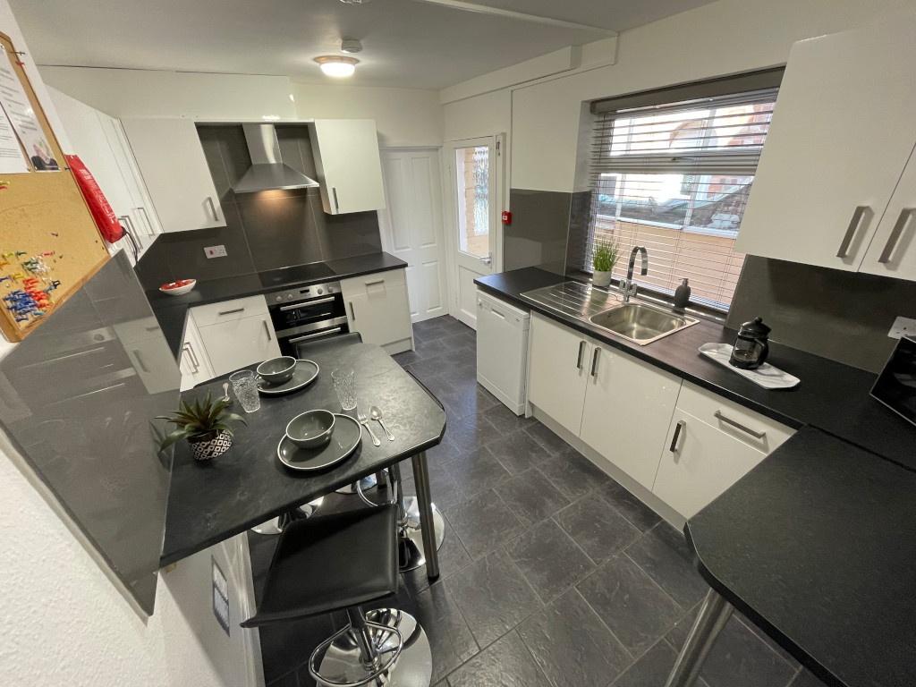 Modern galley kitchen with sleek black worktops...
