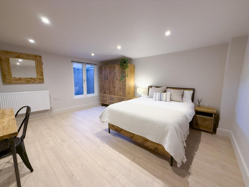 Bright, modern master bedroom with a comfortabl...