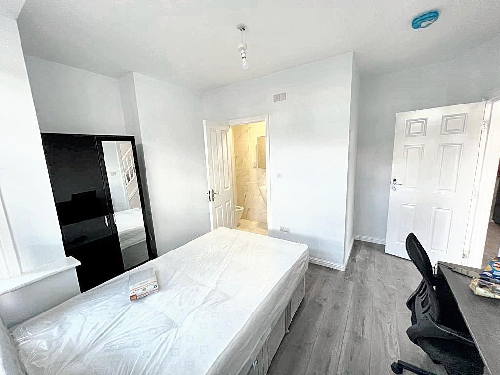Bright, freshly painted bedroom with a large wi...
