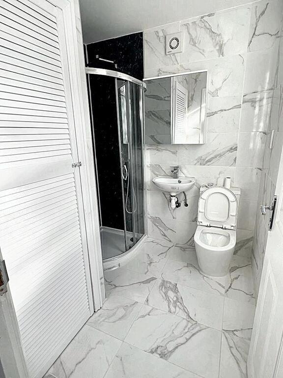 Bright, modern bathroom with marble-effect tile...