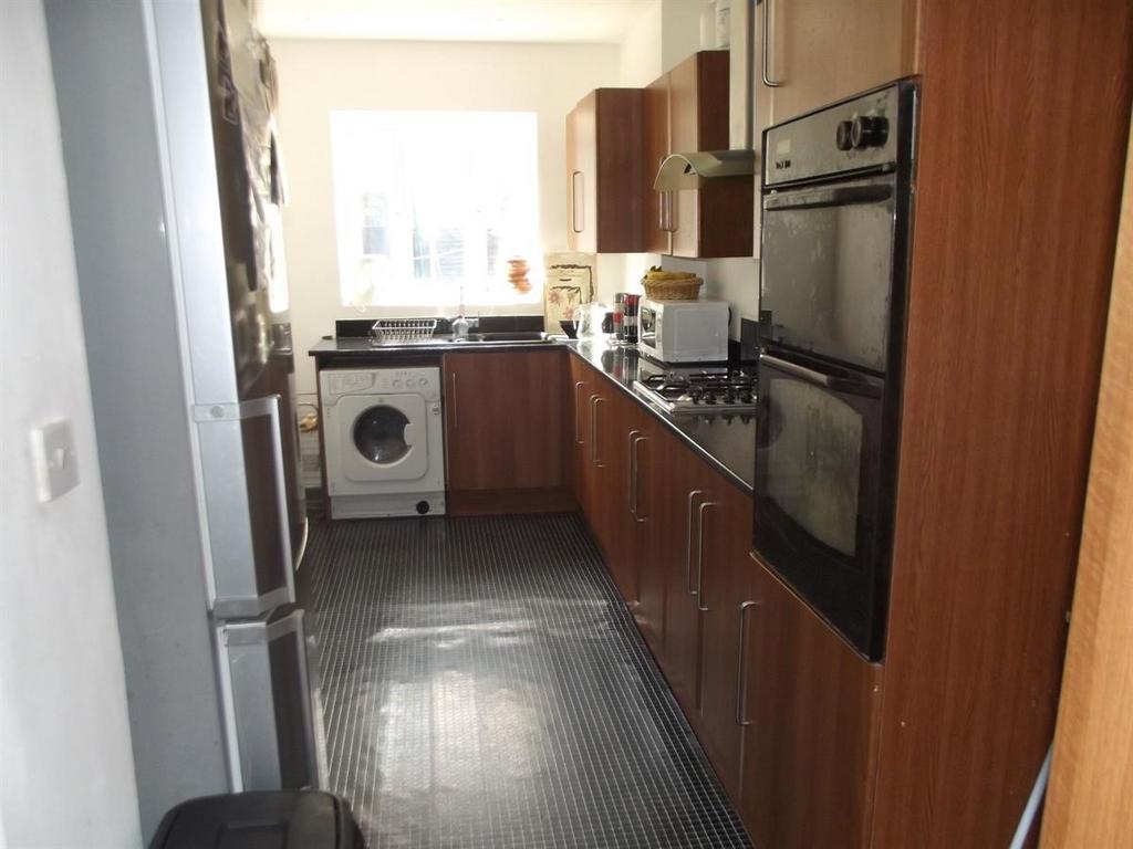 Long galley kitchen with wood-effect cabinets, ...