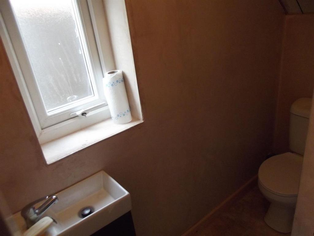 Compact WC with a small basin beneath a frosted...
