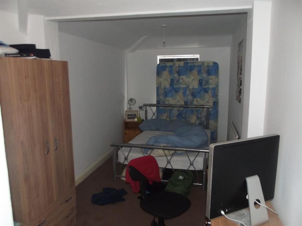 Cozy bedroom with a metal bed frame, wooden war...