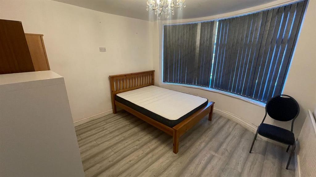 Bright, simply furnished bedroom with a wooden ...