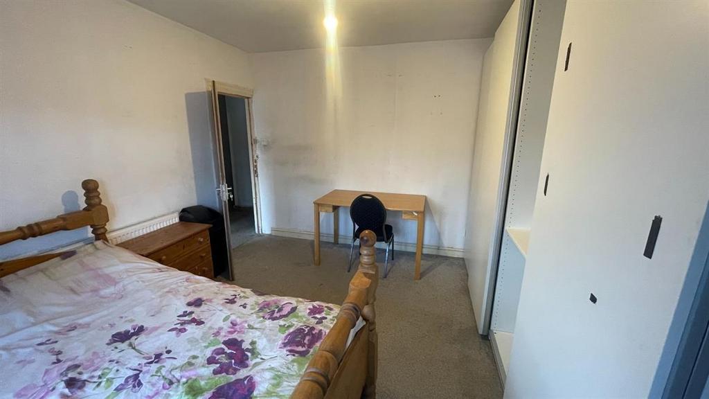 Bright, simply furnished bedroom with a comfort...