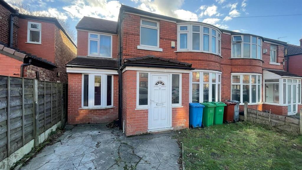 Red-brick terraced house with a paved driveway,...