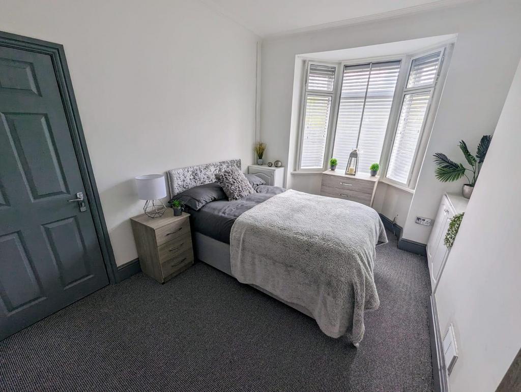 Bright, neatly styled bedroom with a comfortabl...