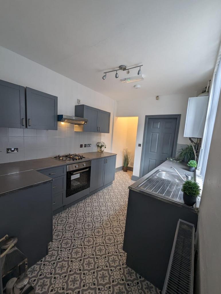 Modern galley kitchen with patterned tiled floo...