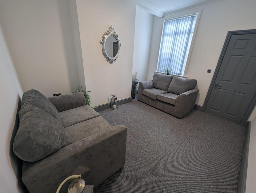 Bright, neatly presented living room with two c...