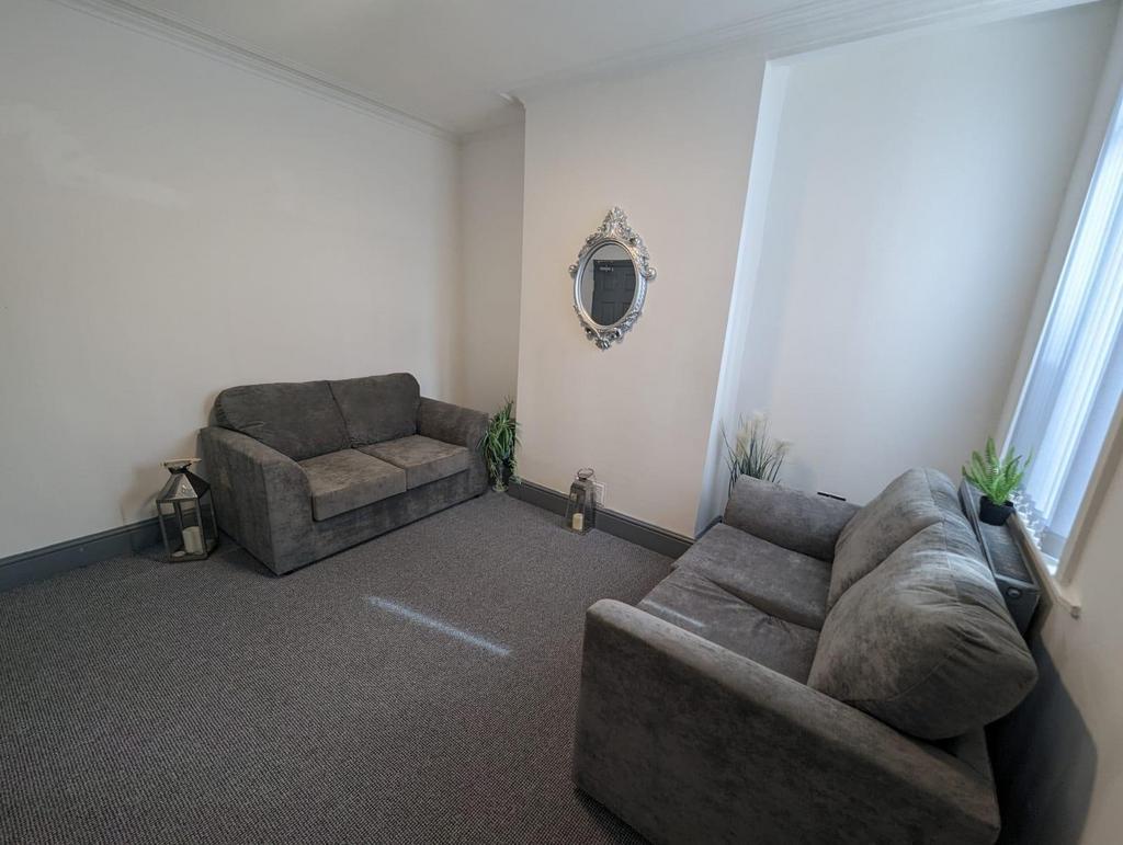 Bright, neutrally decorated living room with tw...