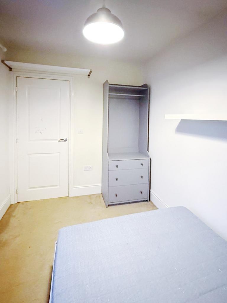 Neat, simply furnished bedroom with a built-in ...