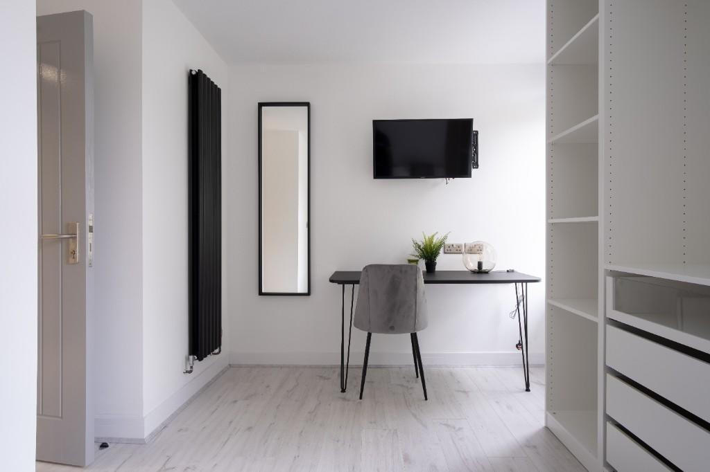Bright and modern single bedroom featuring a cl...