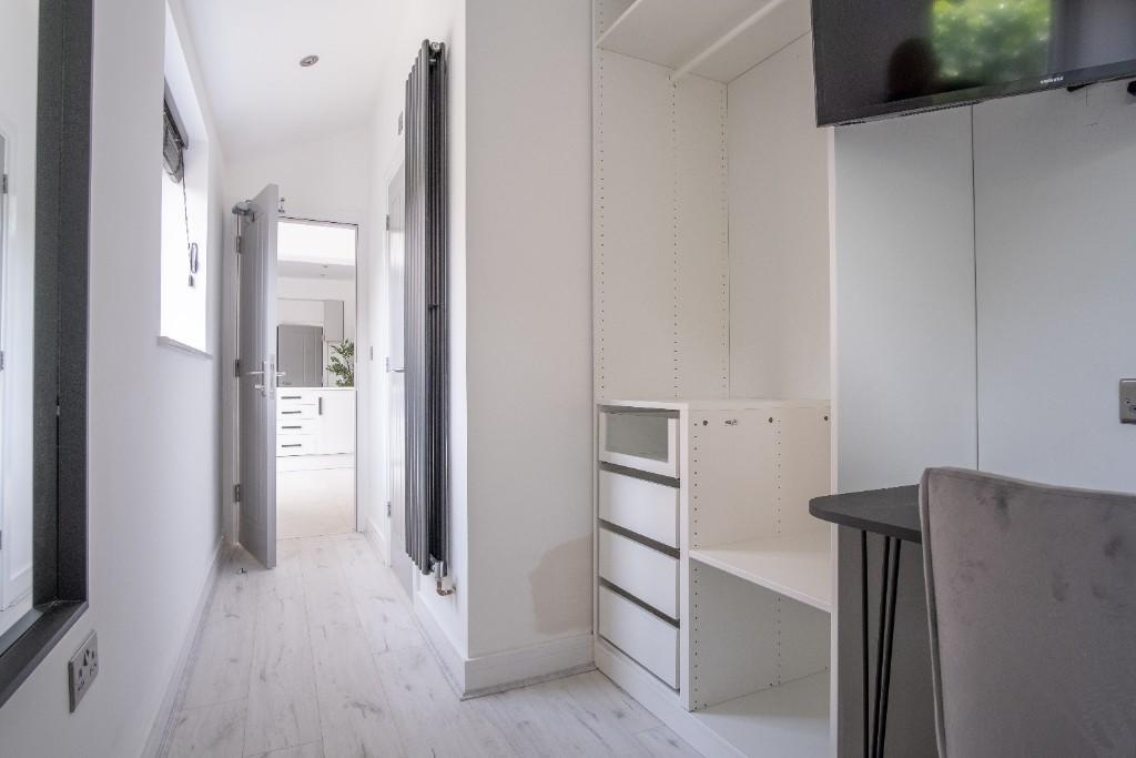 A bright and clean hallway with white walls and...