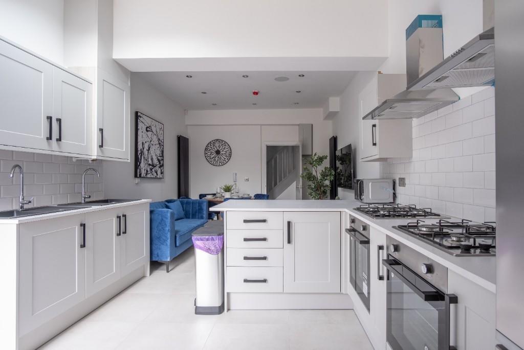 A modern, clean kitchen with white cabinetry, a...