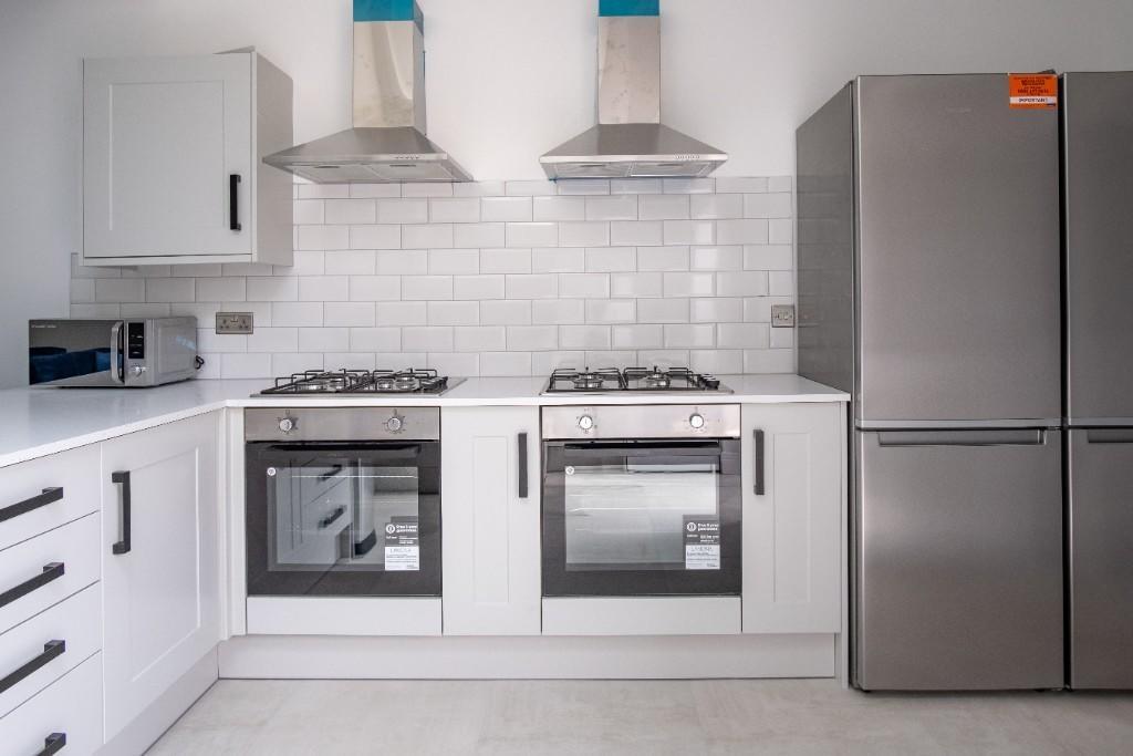Modern kitchen with bright white cabinetry, dua...