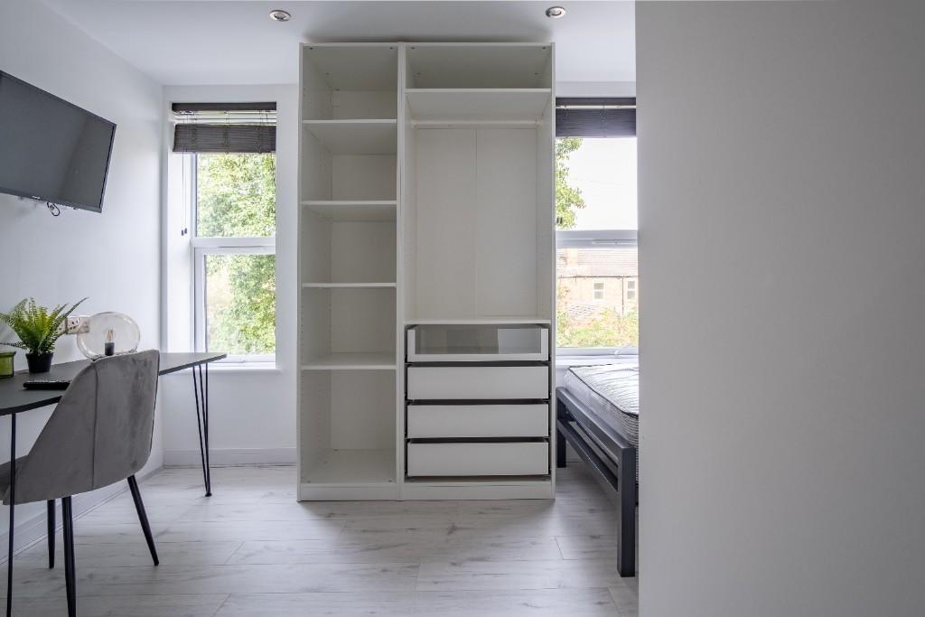 A bright and tidy single bedroom featuring a we...