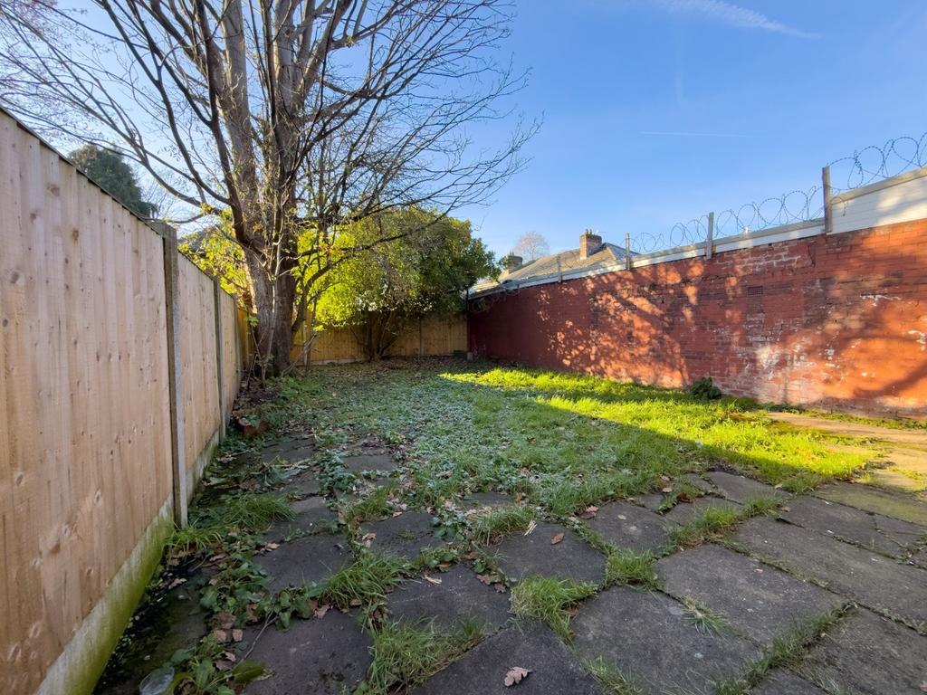 Sunlit private rear garden with a paved patio a...