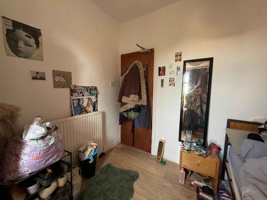 Cozy furnished bedroom with light wood floors, ...