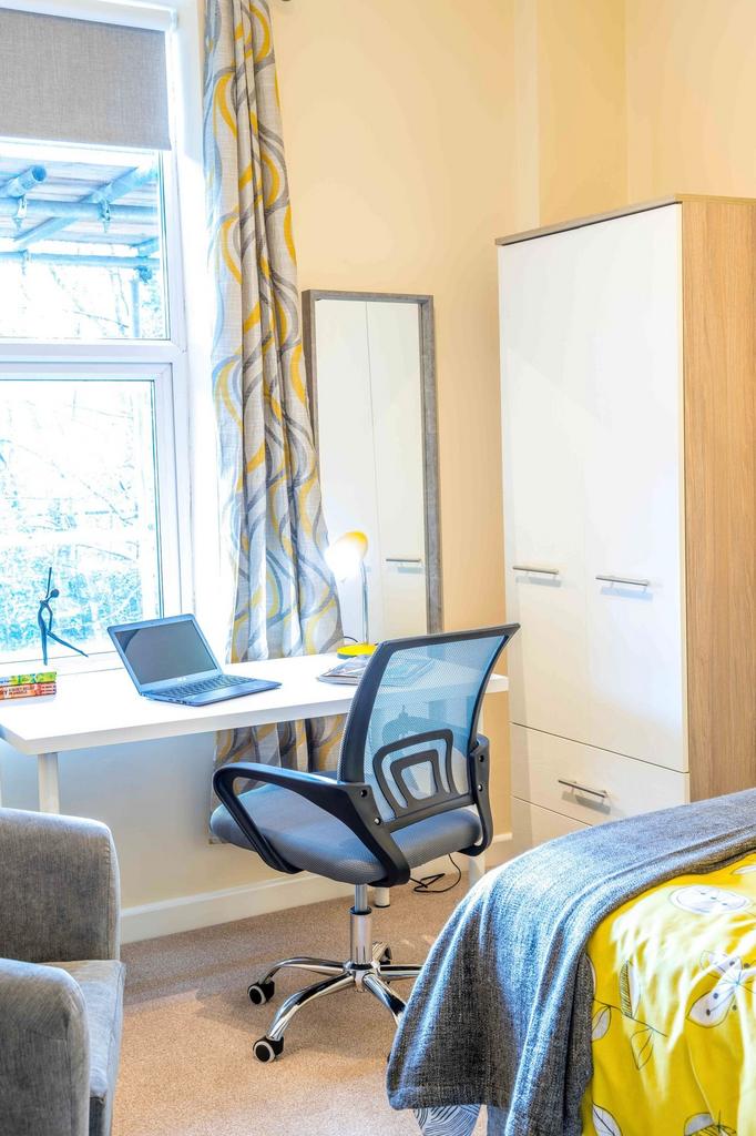 Bright, modern bedroom with a study area by a l...