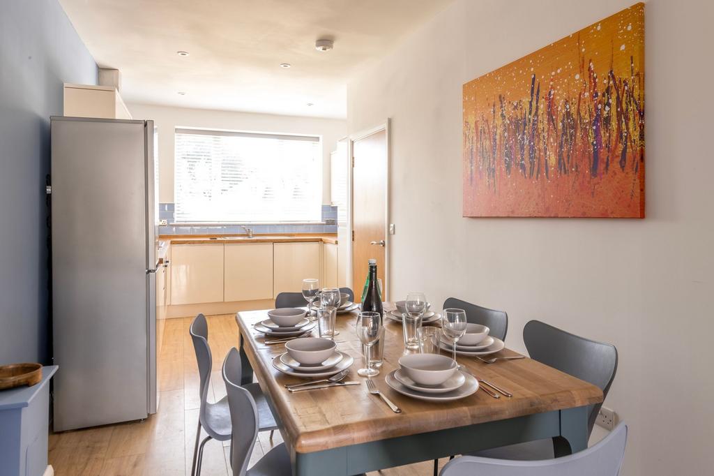 Bright, modern kitchen-diner with a wooden dini...