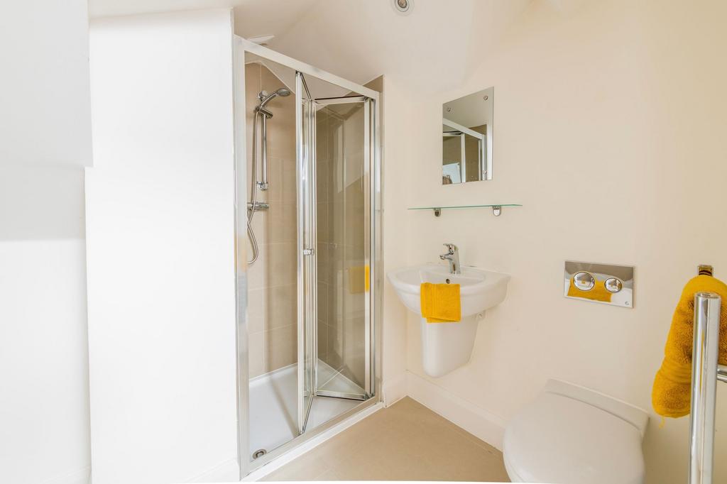 Bright, modern bathroom with a corner shower en...