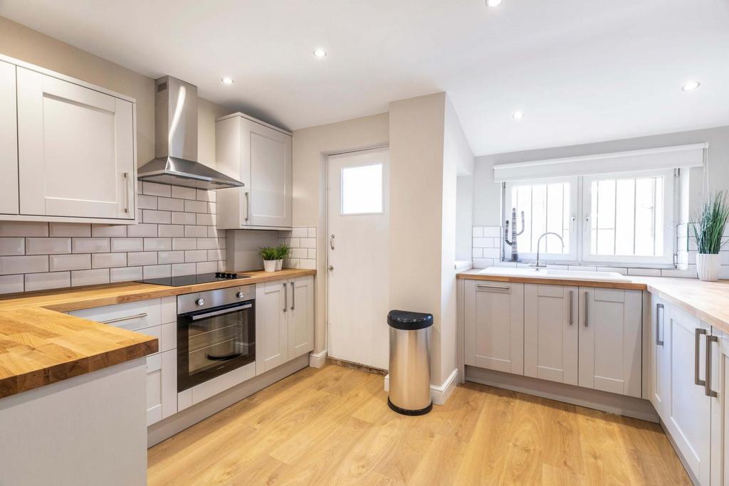 Bright, modern kitchen with wood countertops, i...