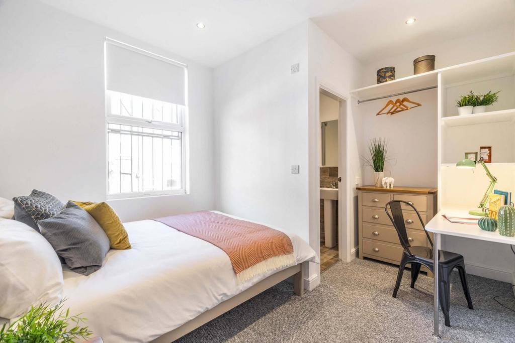 Bright, neatly furnished double bedroom with a ...