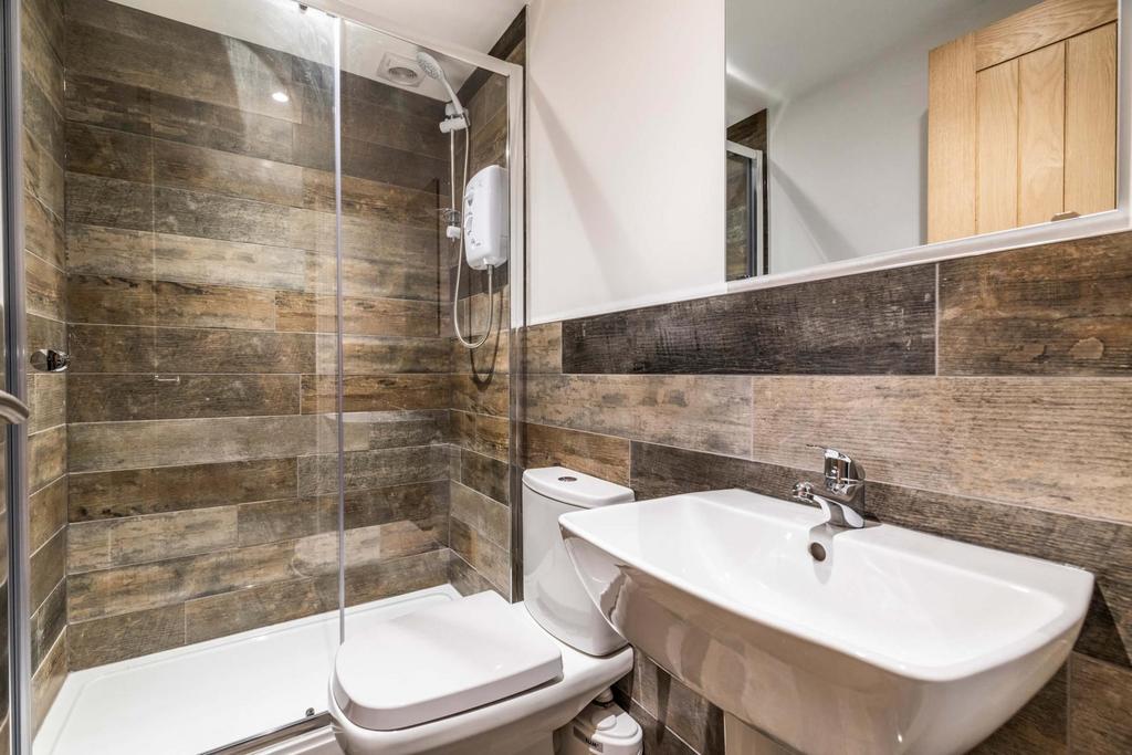 Modern ensuite bathroom with a walk-in glass sh...