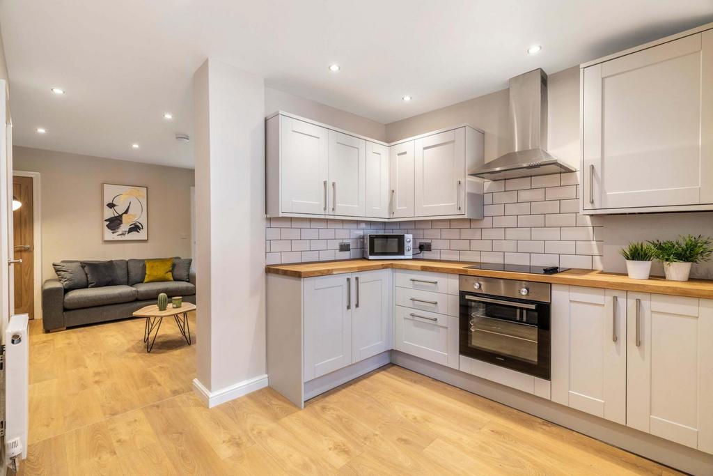 Modern open-plan kitchen with light cabinetry, ...