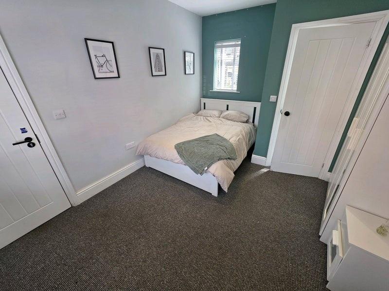 A neat and cozy double bedroom featuring a comf...