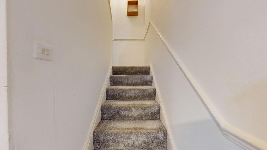 Carpeted interior staircase with neutral white ...