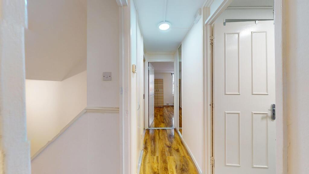 Bright, well-maintained hallway with fresh whit...