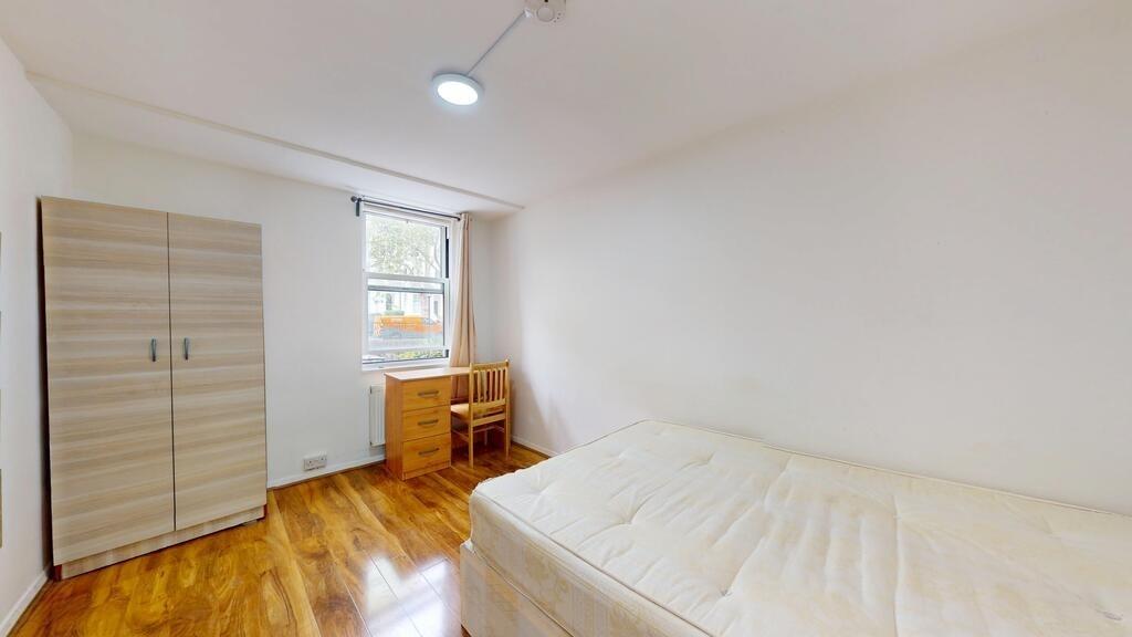 Bright, simply furnished single bedroom with a ...