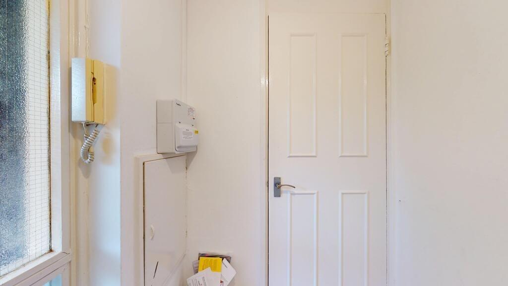 Bright, clean entrance hallway with a white pan...