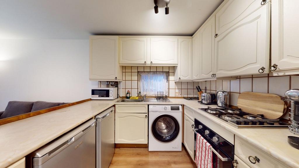 Bright, well-equipped kitchen with cream cabine...