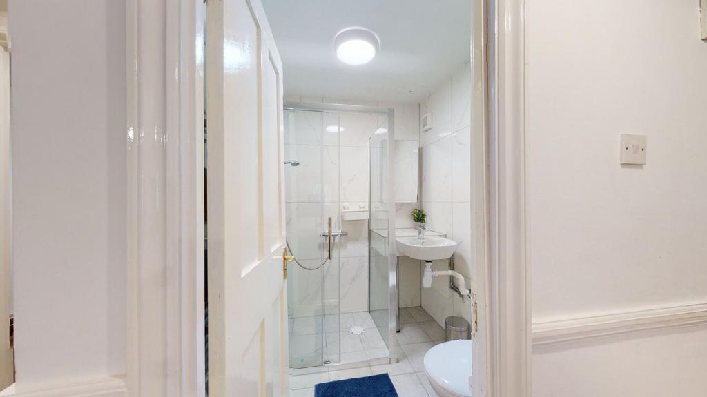 Bright, modern bathroom with a glass-enclosed s...