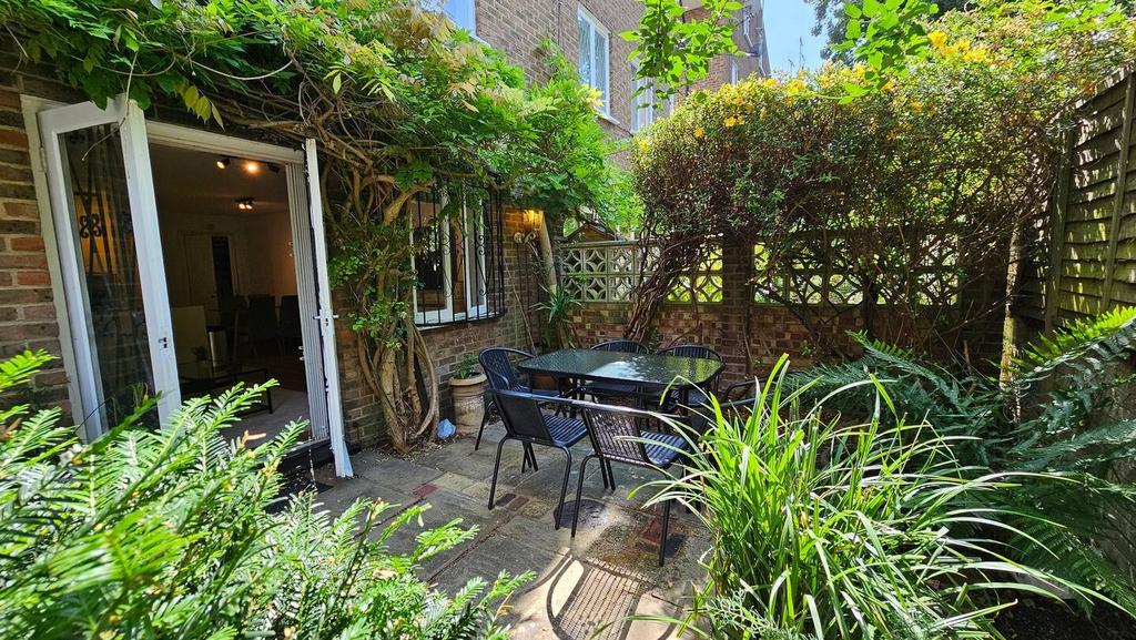 Sunny private patio garden with outdoor dining ...