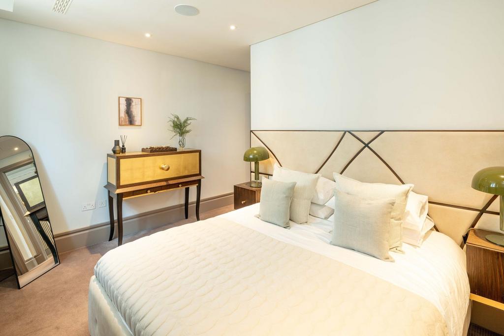 Bright, stylish master bedroom with a large uph...