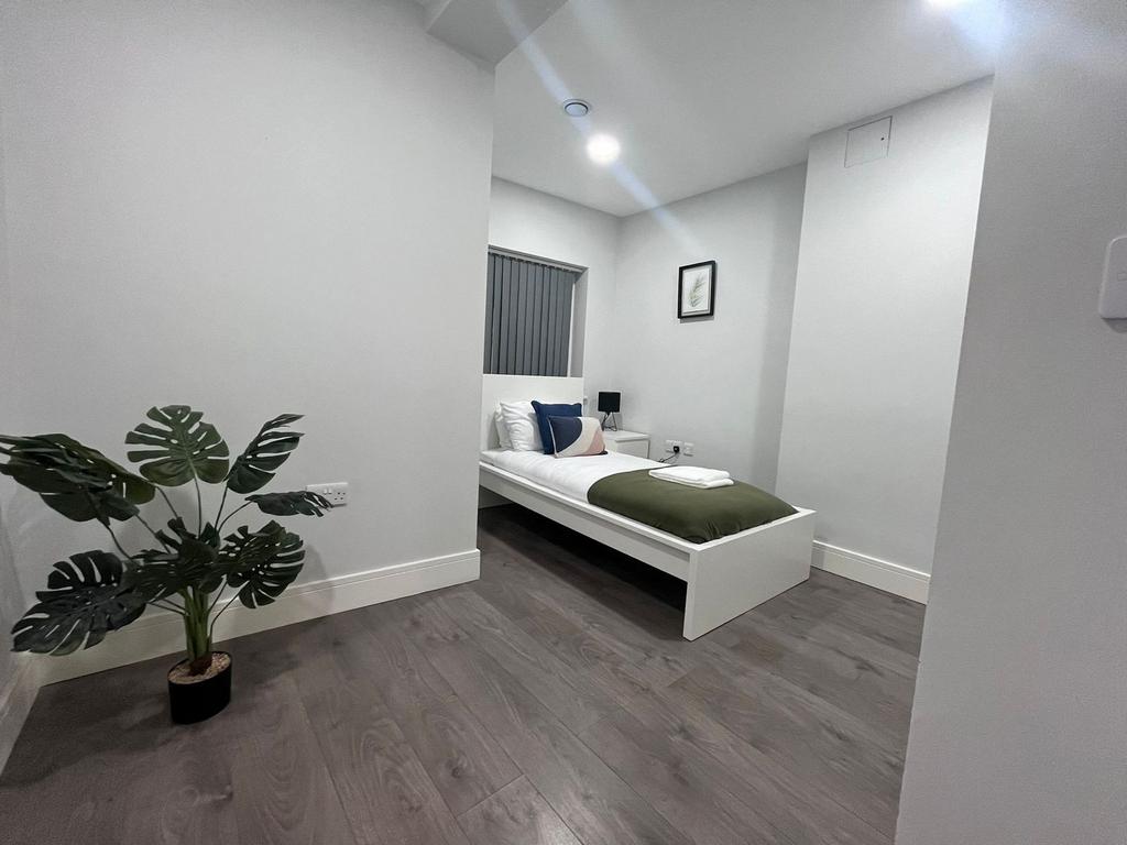 Bright, modern single bedroom with clean white ...