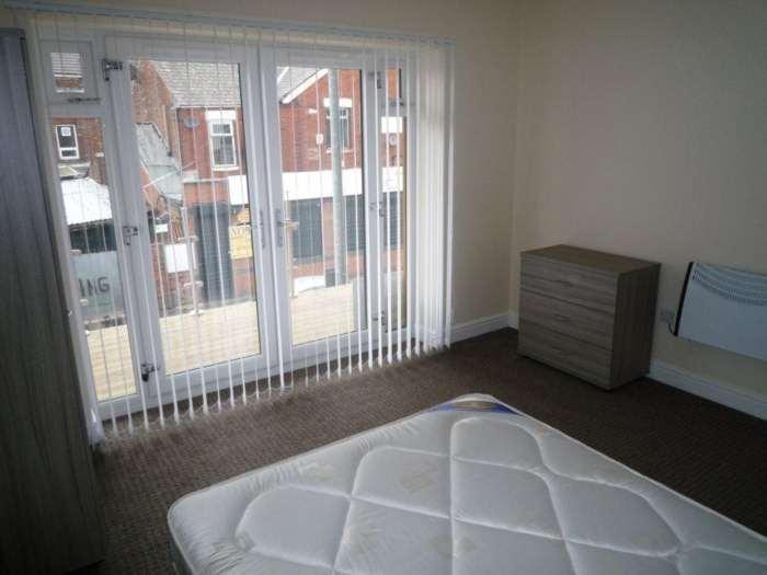 Bright and airy bedroom with large sliding glas...